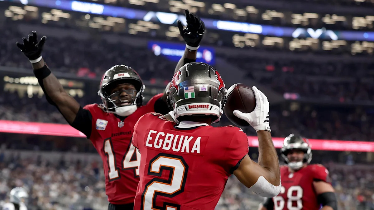 Emeka Egbuka comemora com companheiros dos Buccaneers no AT&T Stadium.