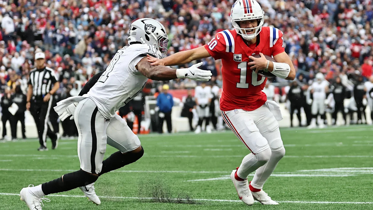 Quarterback dos Raiders carrega a bola durante uma partida.