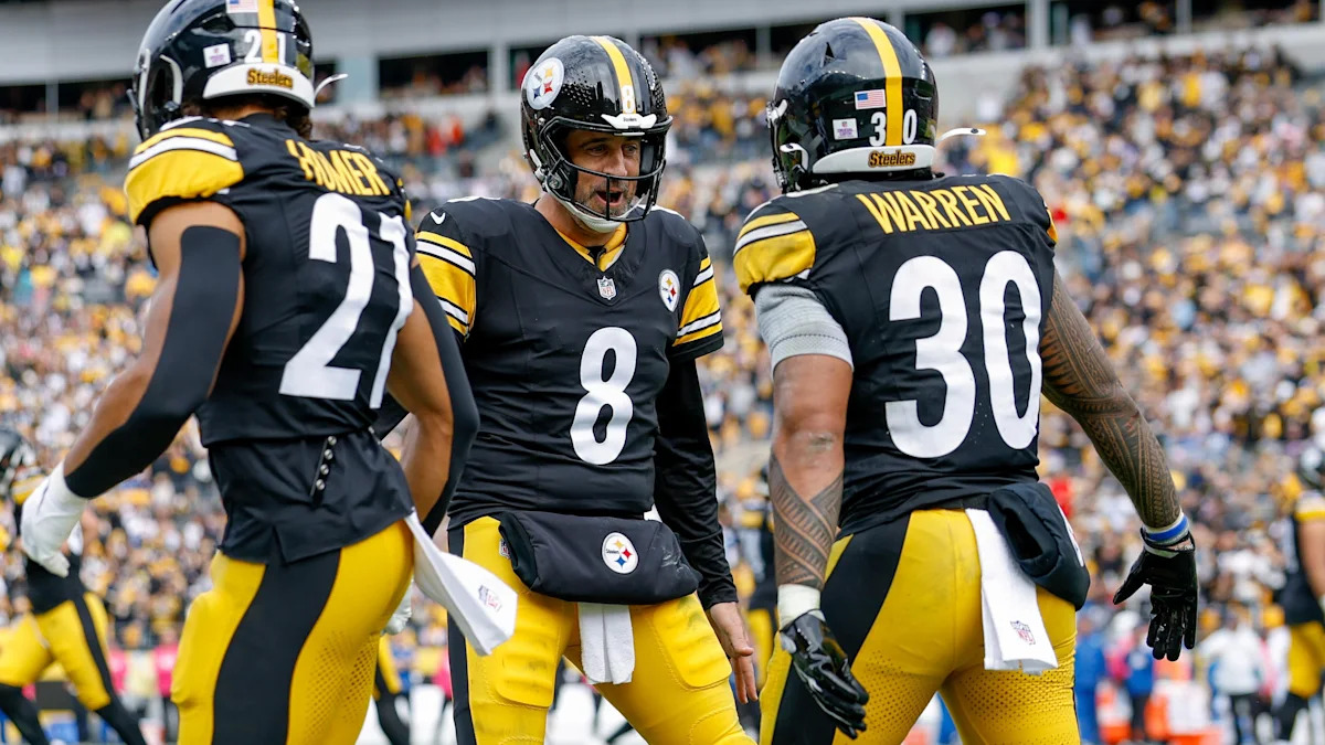 Aaron Rodgers conversa com jogadores dos Steelers em campo.