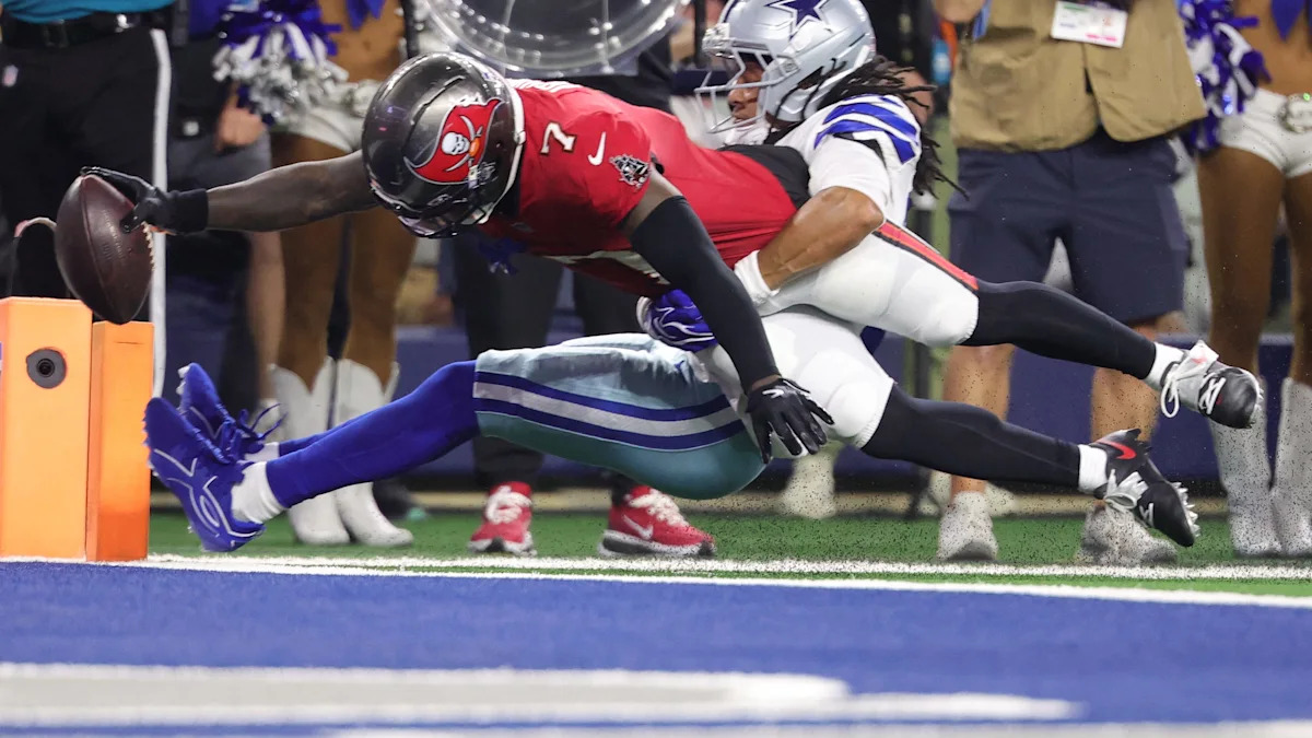 Bucky Irving mergulha para marcar um touchdown contra a defesa dos Cowboys.