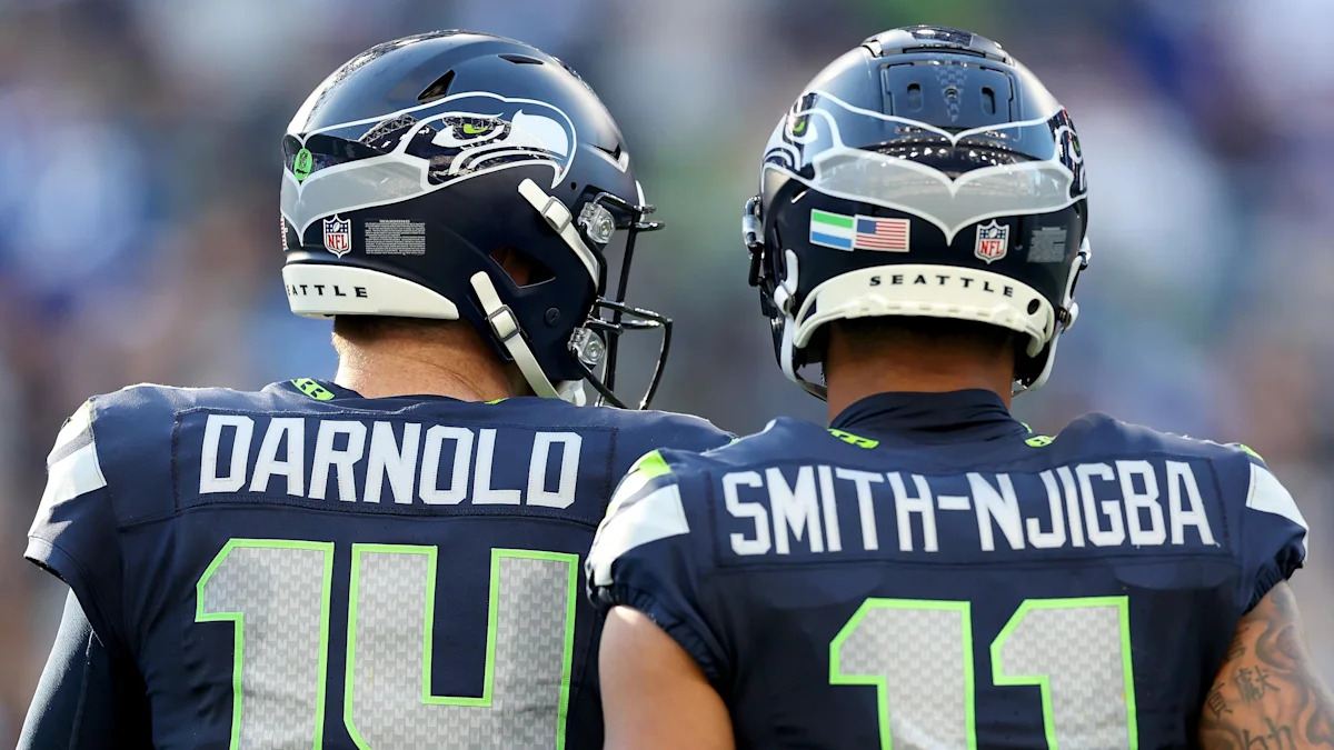 Sam Darnold e Jaxon Smith-Njigba com uniformes dos Seahawks.