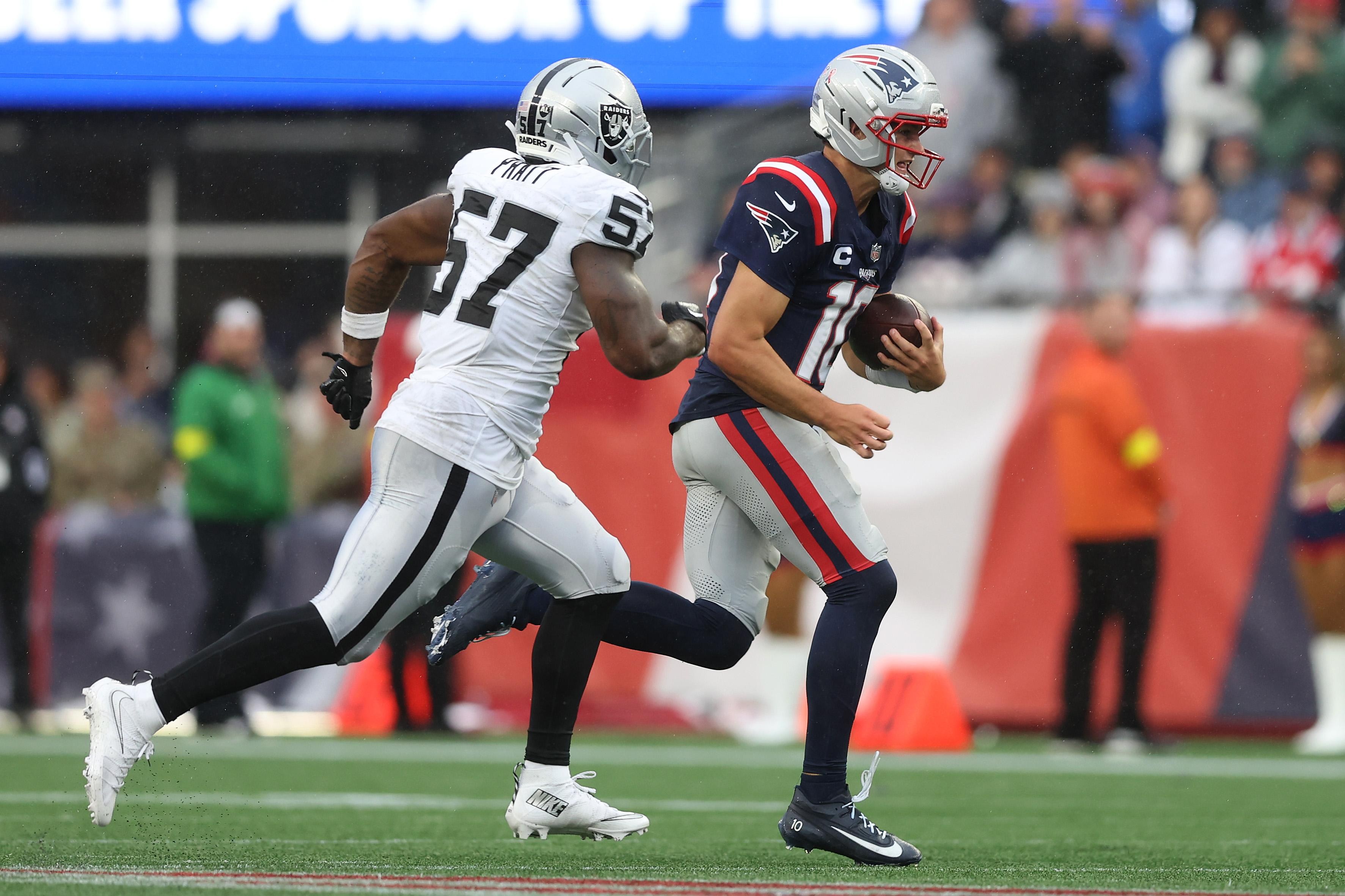 Drake Maye corre com a bola durante um jogo dos Patriots contra os Raiders.