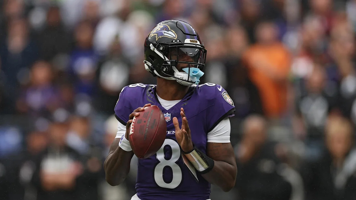 Lamar Jackson com uniforme dos Ravens; quarterback segue em recuperação de lesão no tornozelo.