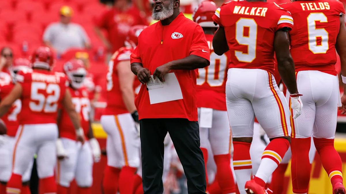Eric Bieniemy orienta jogadores dos Chiefs durante atividade em campo.