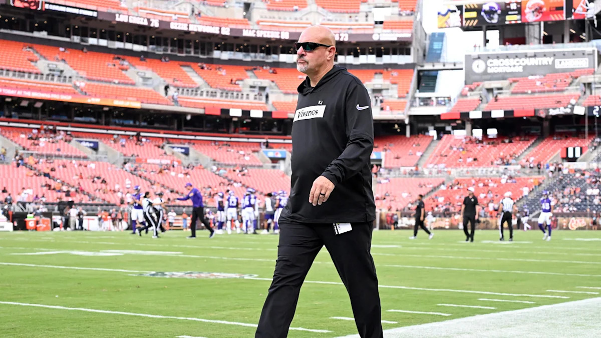Mike Pettine em campo antes de uma partida; assistente contribui na preparação da defesa de Dallas.