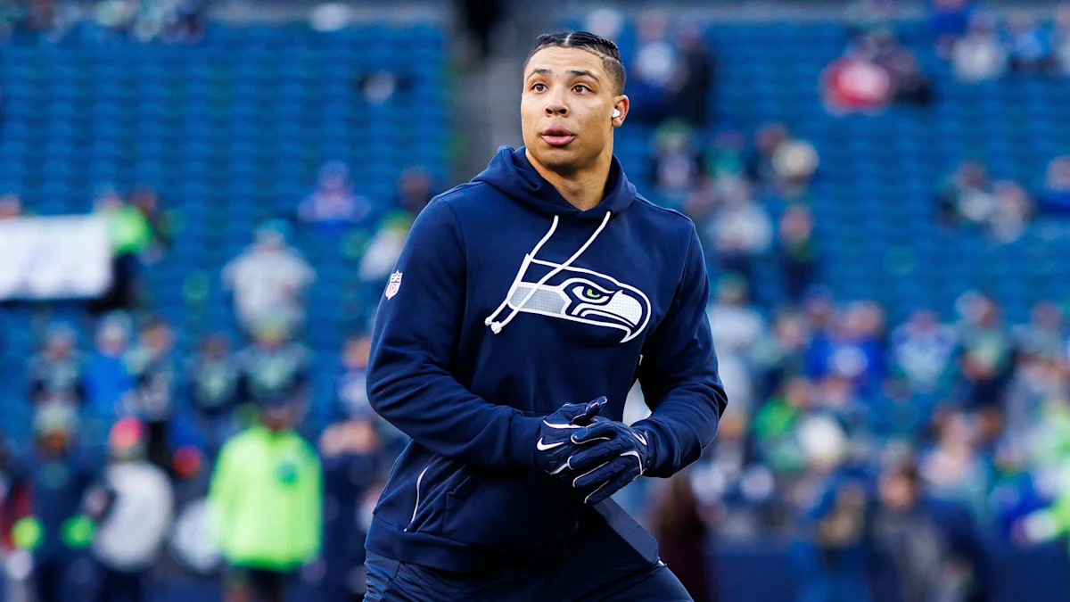 Jogador dos Seahawks durante aquecimento; imagem ilustrativa da enquete sobre a temporada.