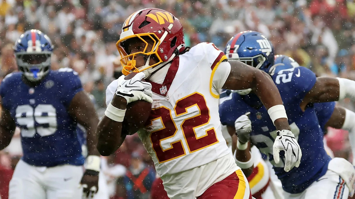 Jacory Croskey-Merritt carrega a bola pelos Commanders diante dos Giants.