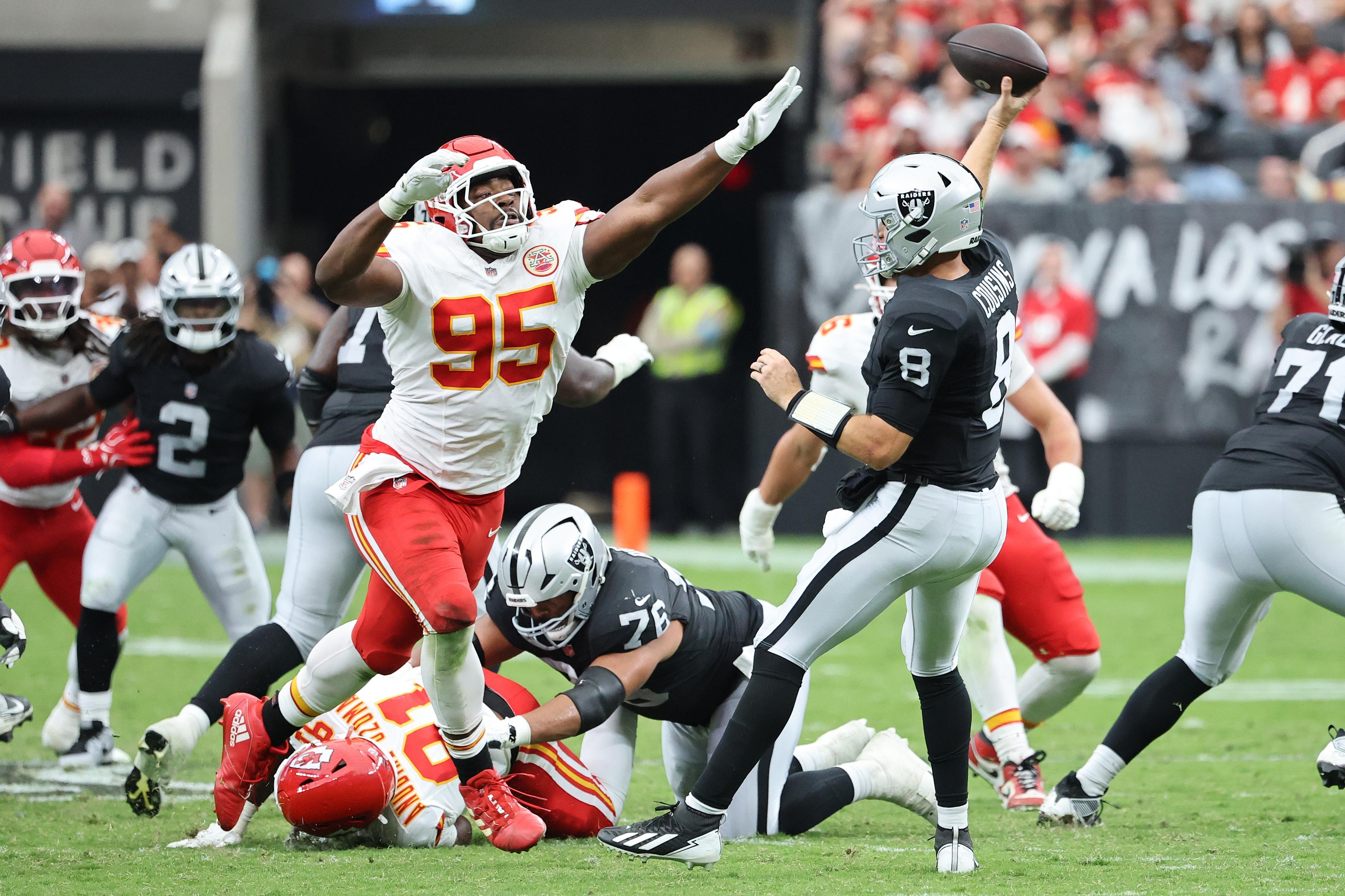 Defensores dos Chiefs tentam conter uma jogada dos Raiders.