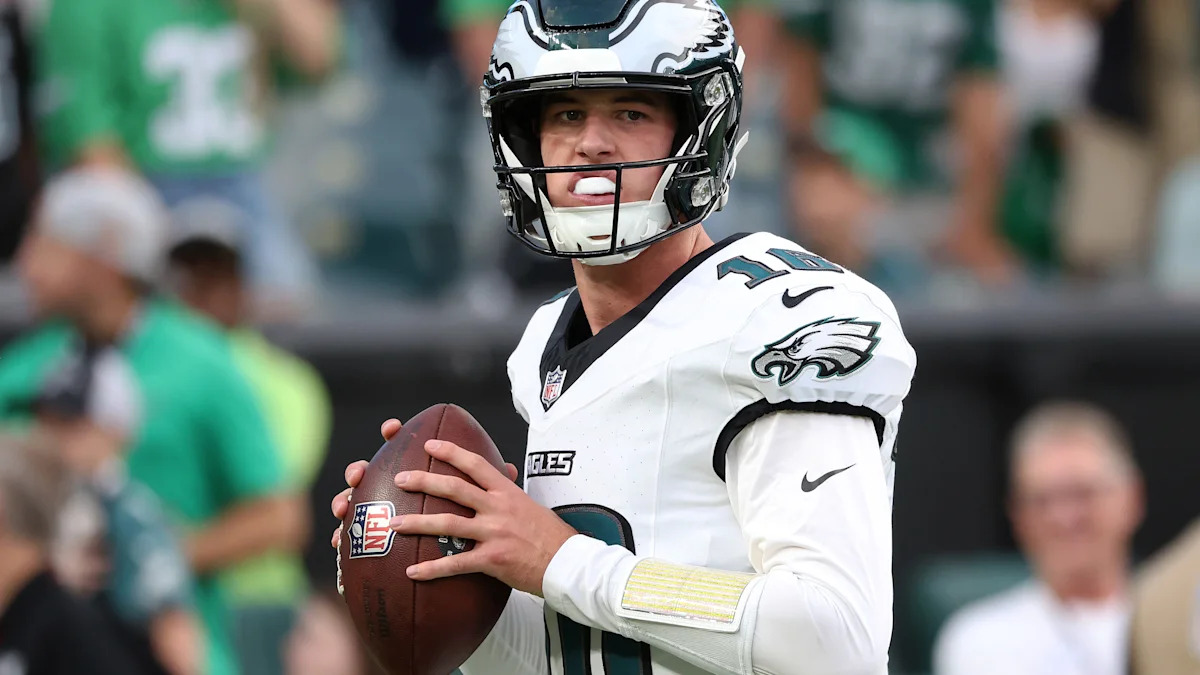 Tanner McKee com a bola e uniforme dos Eagles; imagem ilustrativa do quarterback.