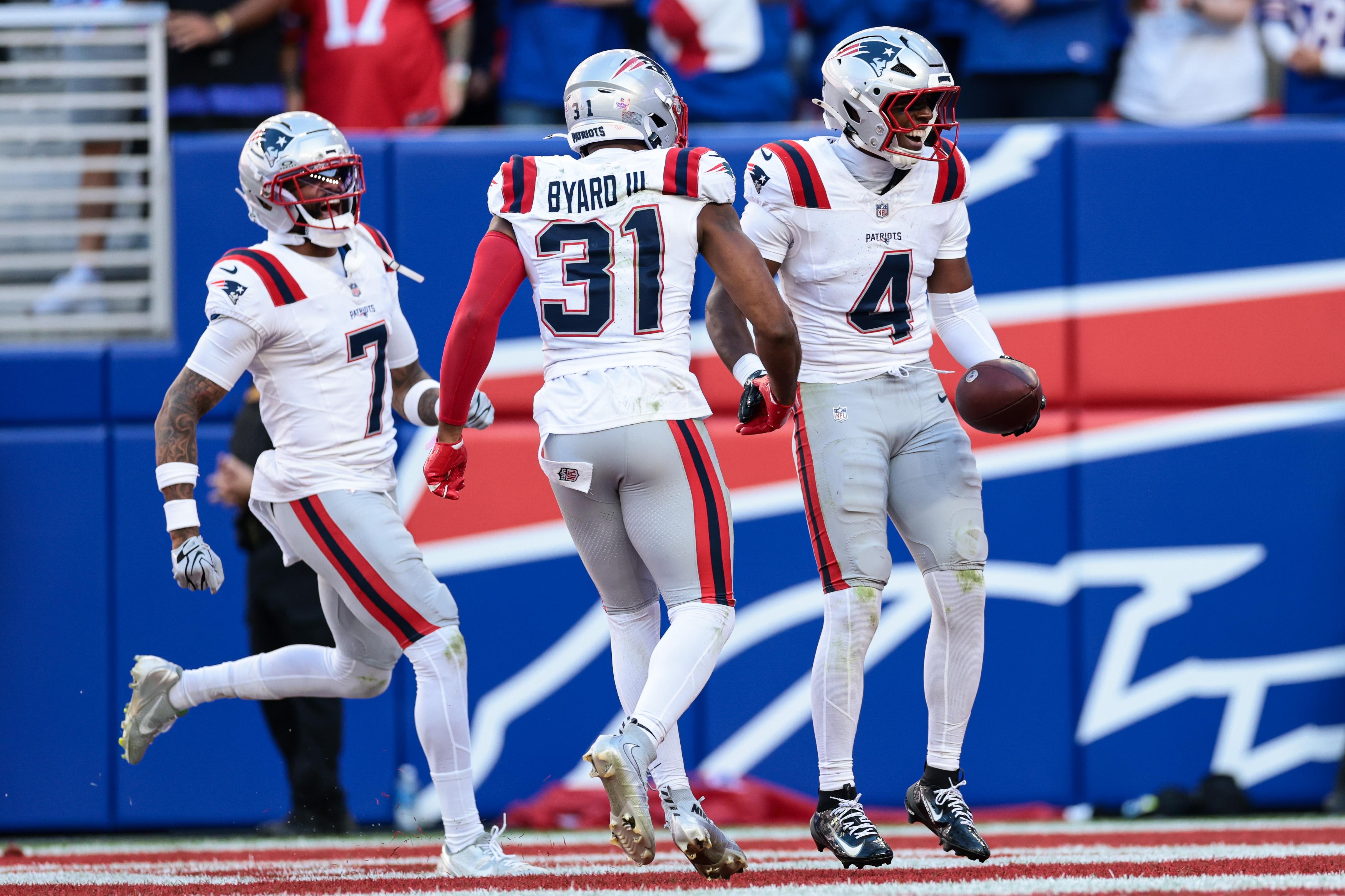 Defensores dos Patriots comemoram em campo.