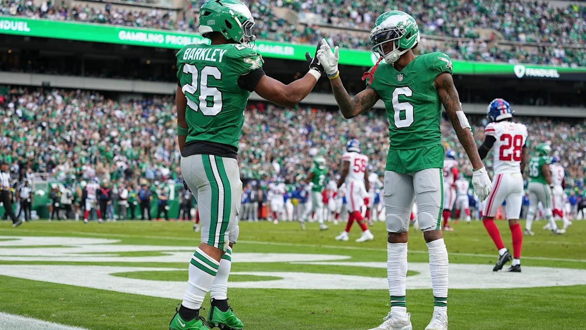 Saquon Barkley e DeVonta Smith com uniforme dos Eagles em campo.