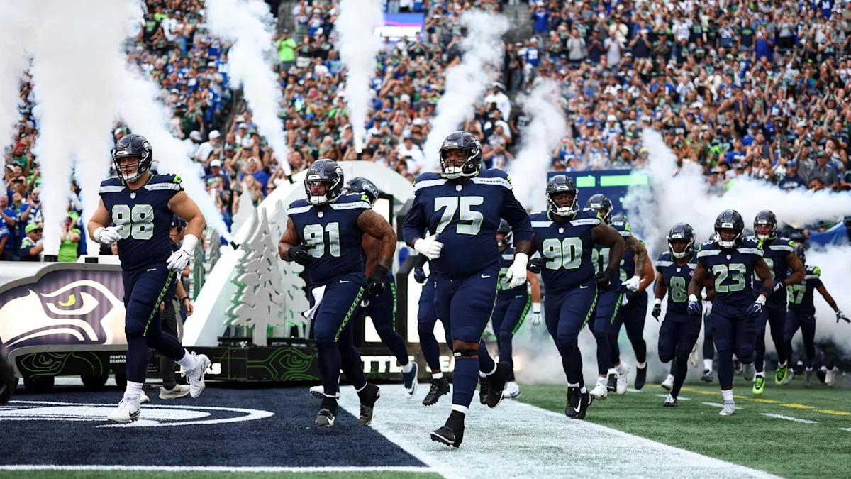 Jogadores dos Seahawks entram em campo; equipe acompanha a recuperação de Anthony Bradford.