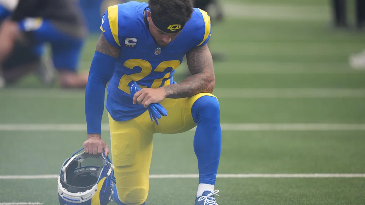 Trent McDuffie se ajoelha com uniforme dos Rams; cornerback é dúvida por lesão na virilha.