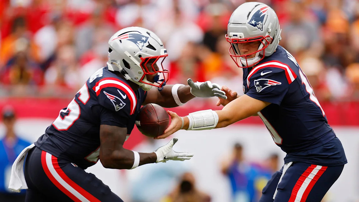 Drake Maye entrega a bola a Terrell Jennings pelos Patriots contra os Buccaneers em novembro de 2025; imagem de arquivo.