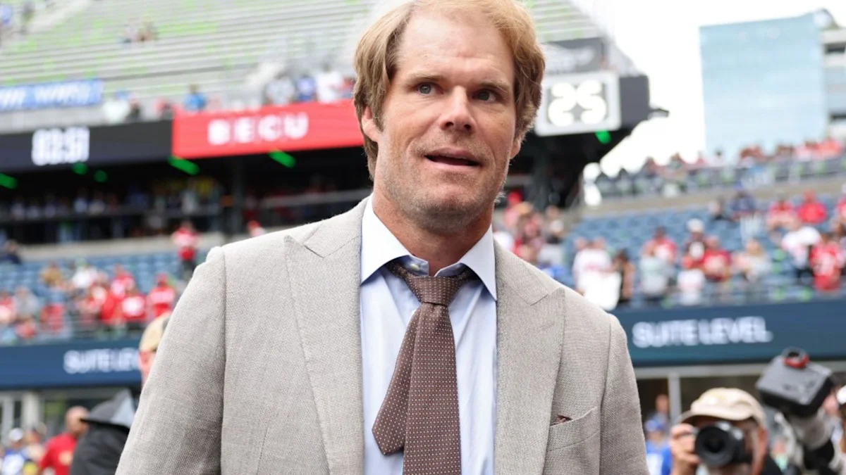 Greg Olsen à beira do campo durante atividade de transmissão esportiva.
