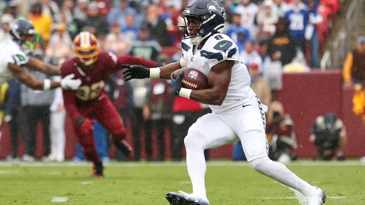 Running back dos Seahawks carrega a bola durante uma partida da NFL.