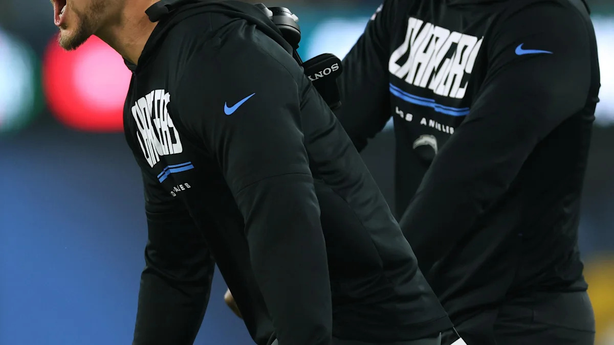 Integrantes da comissão técnica dos Chargers acompanham uma partida.