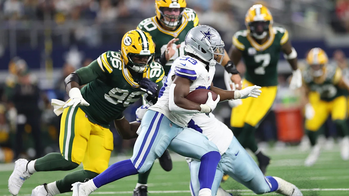 Jogador dos Cowboys avança com a bola contra a defesa dos Packers.