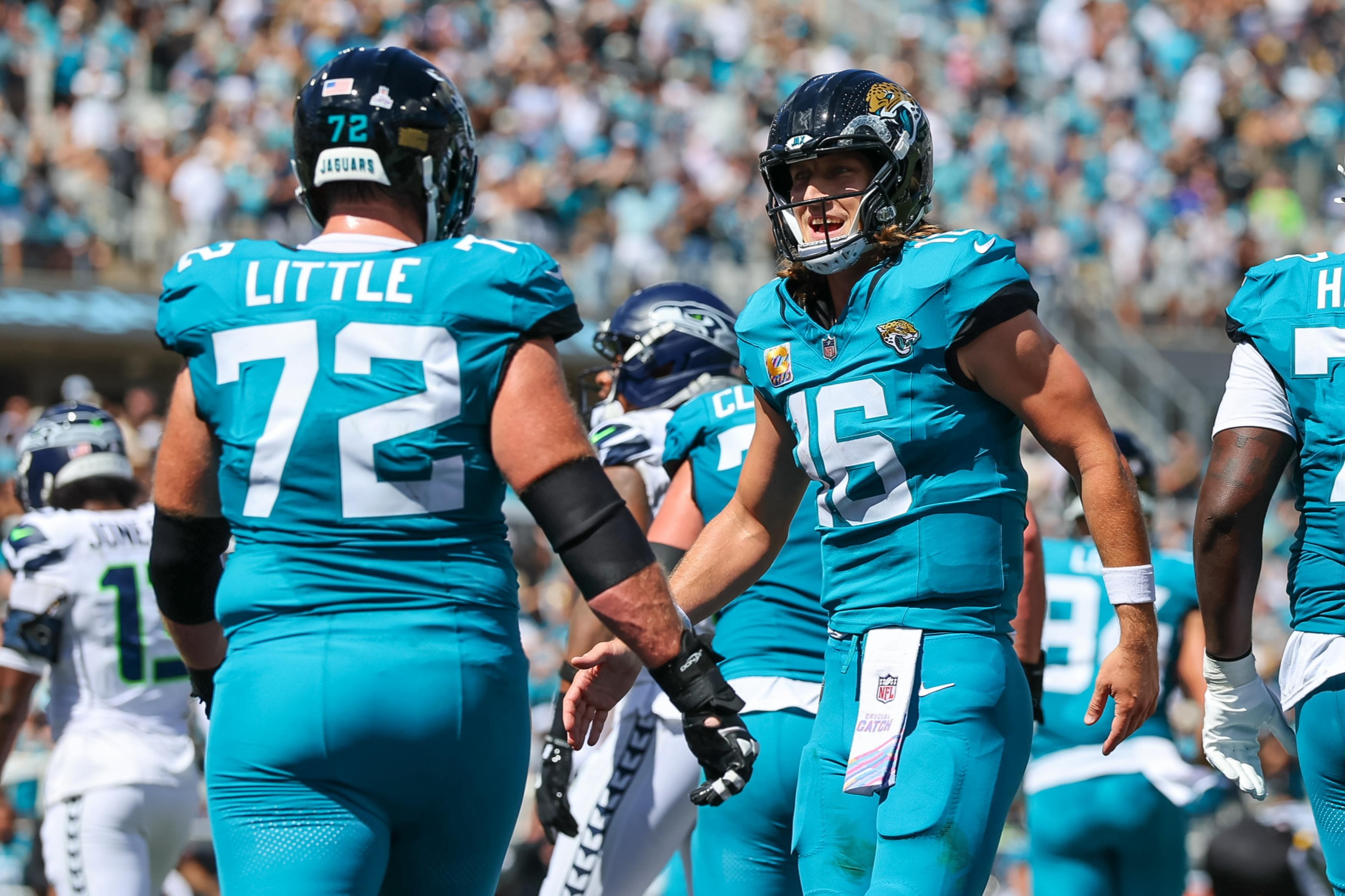 Trevor Lawrence comemora touchdown com Walker Little, dos Jaguars, contra os Seahawks em 12 de outubro de 2025.