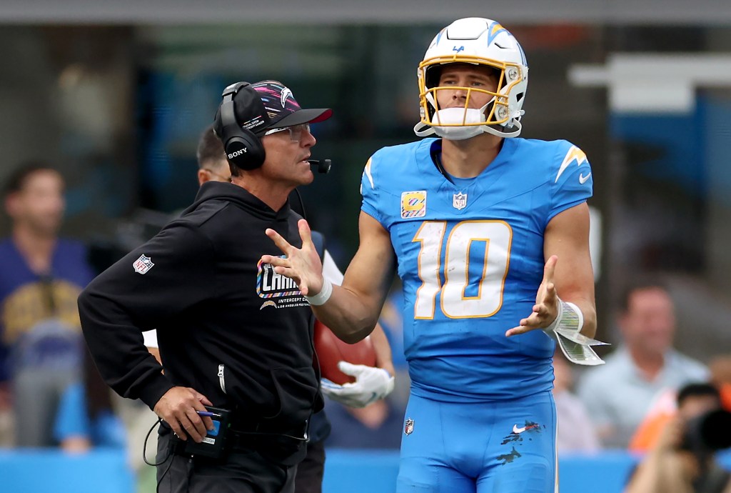 Jim Harbaugh, técnico dos Chargers, conversa com Justin Herbert durante jogo contra o Denver Broncos.