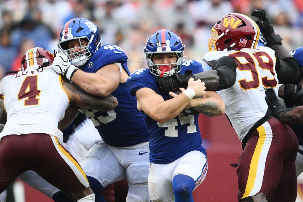 Cam Skattebo avança com a bola durante o empate do Giants com o Washington Commanders, na Semana 5. (Foto: AP)
