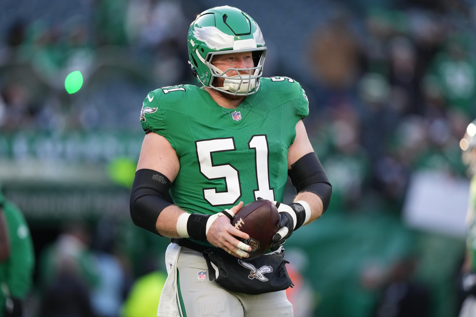 Cam Jurgens, número 51, se aquece pelo Philadelphia Eagles antes de uma partida em 4 de janeiro de 2026.