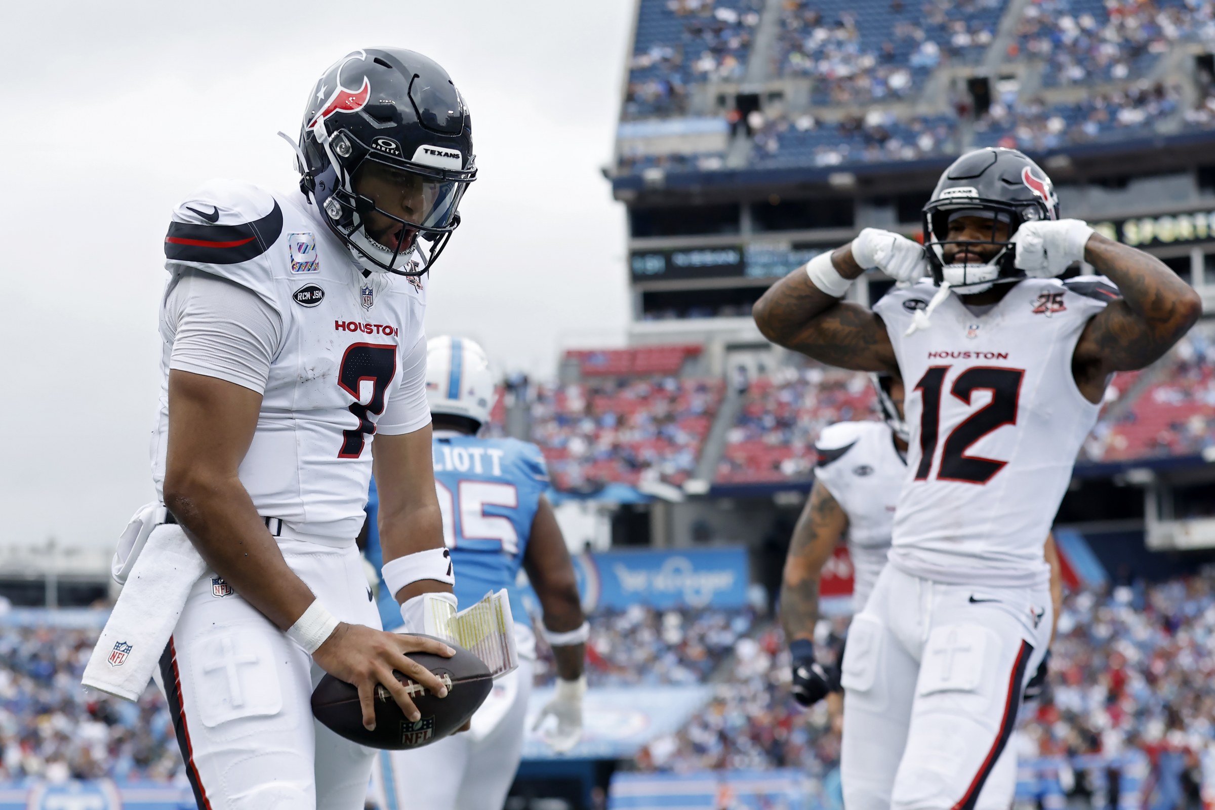C.J. Stroud segura uma bola ao lado de um companheiro dos Houston Texans.