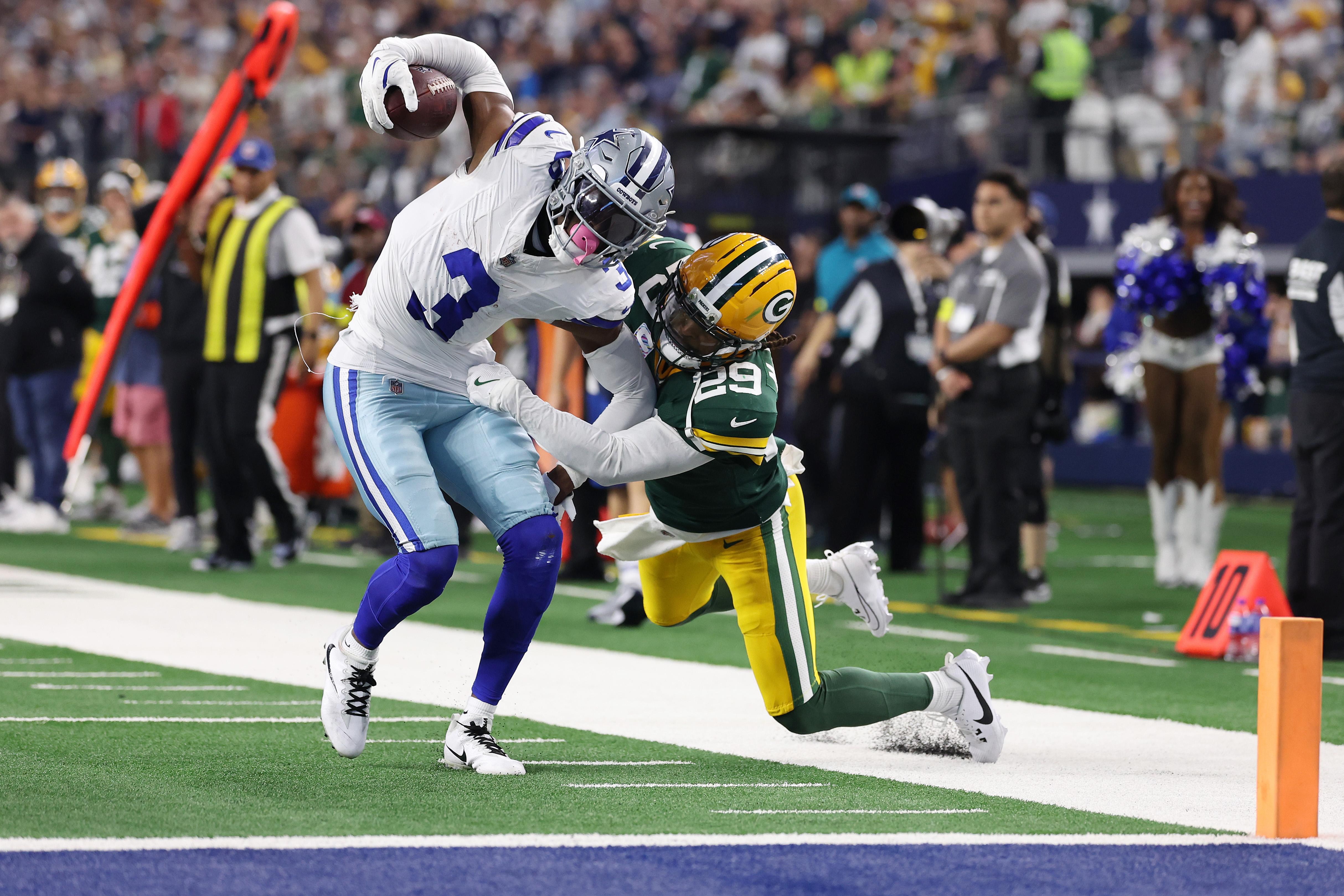 Jogador do Dallas Cowboys carrega a bola durante uma partida contra o Green Bay Packers.