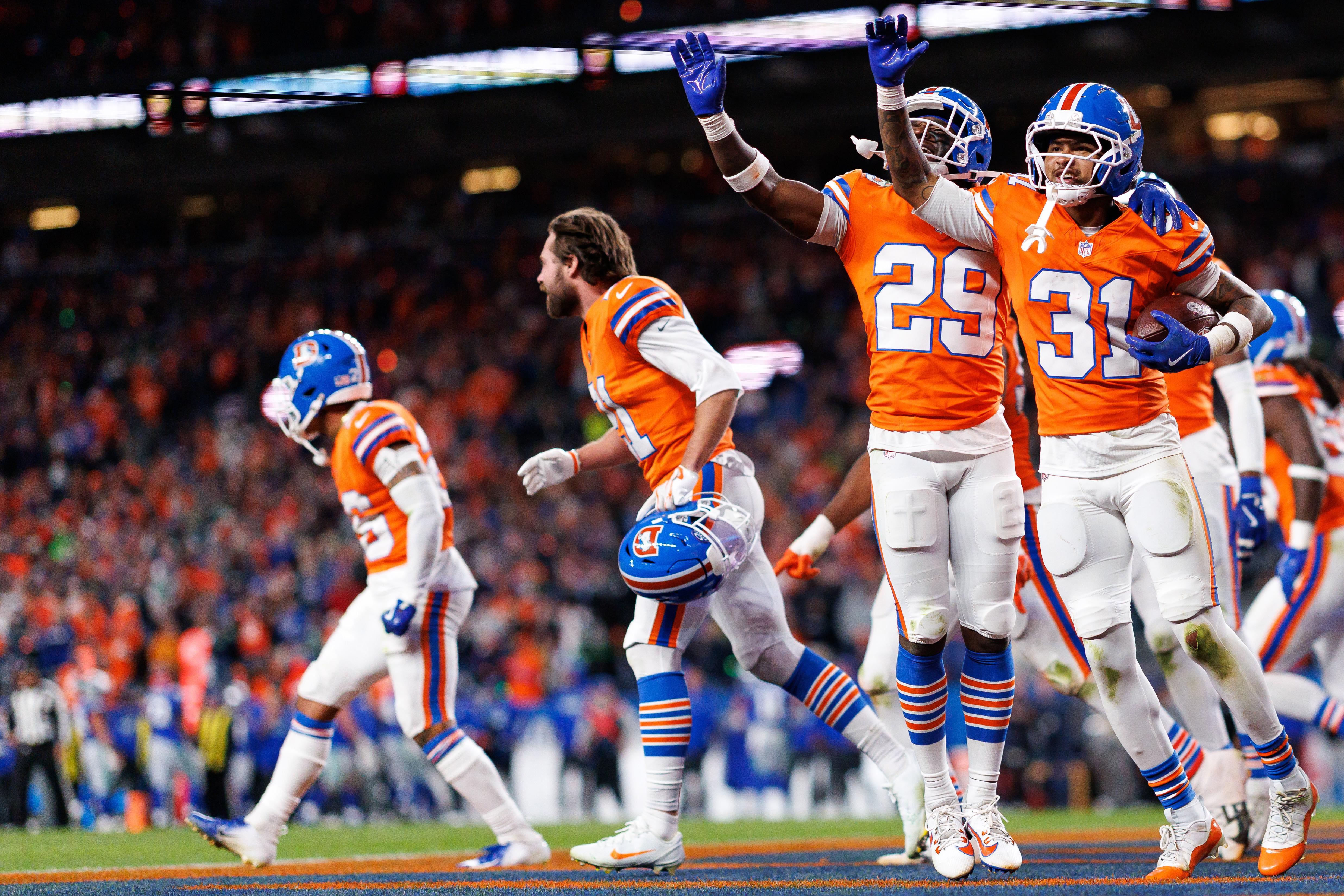Jogadores da defesa do Denver Broncos comemoram durante uma partida.