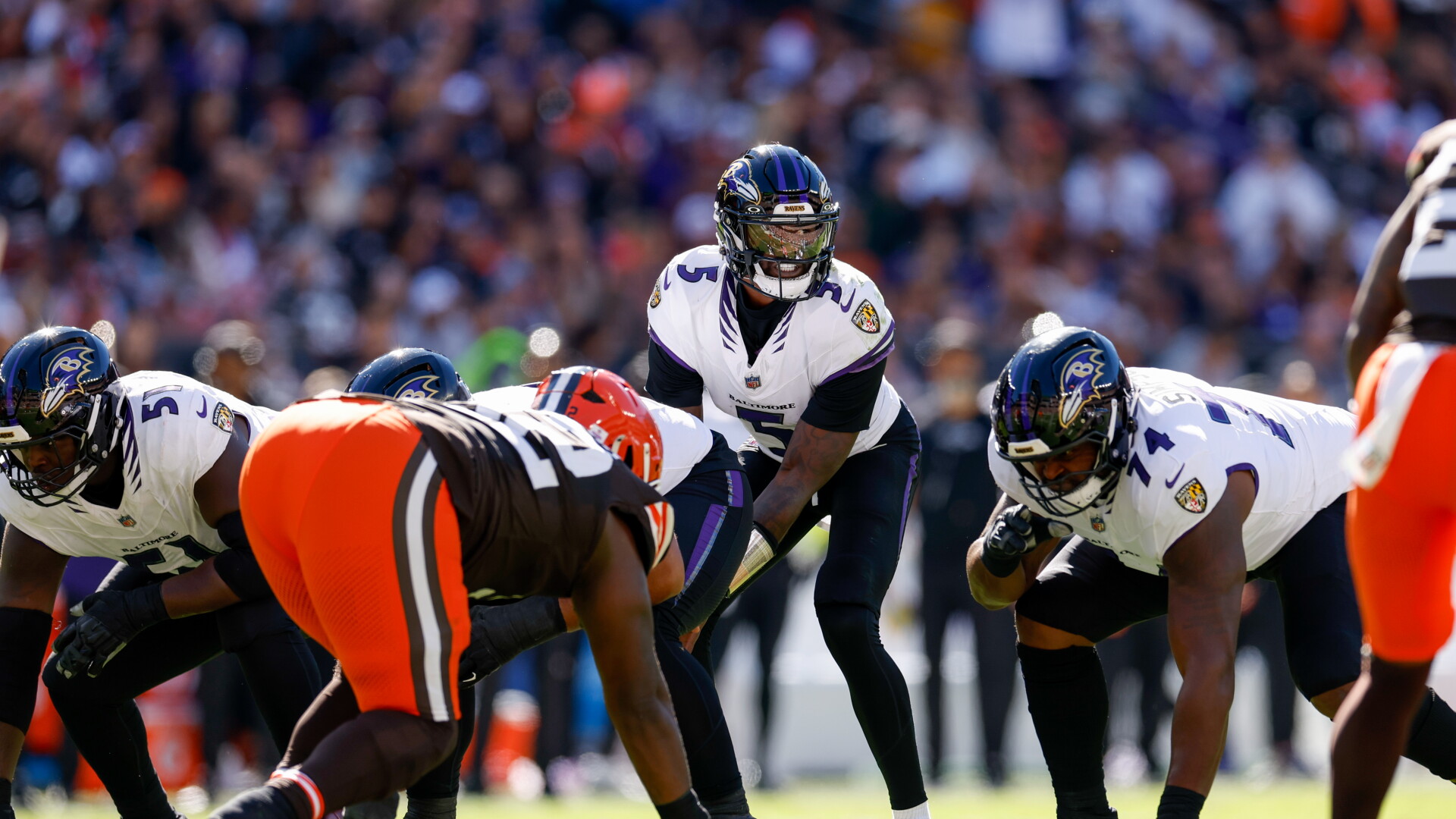 Jogadores do Baltimore Ravens e do Cleveland Browns se posicionam na linha de scrimmage durante um confronto.