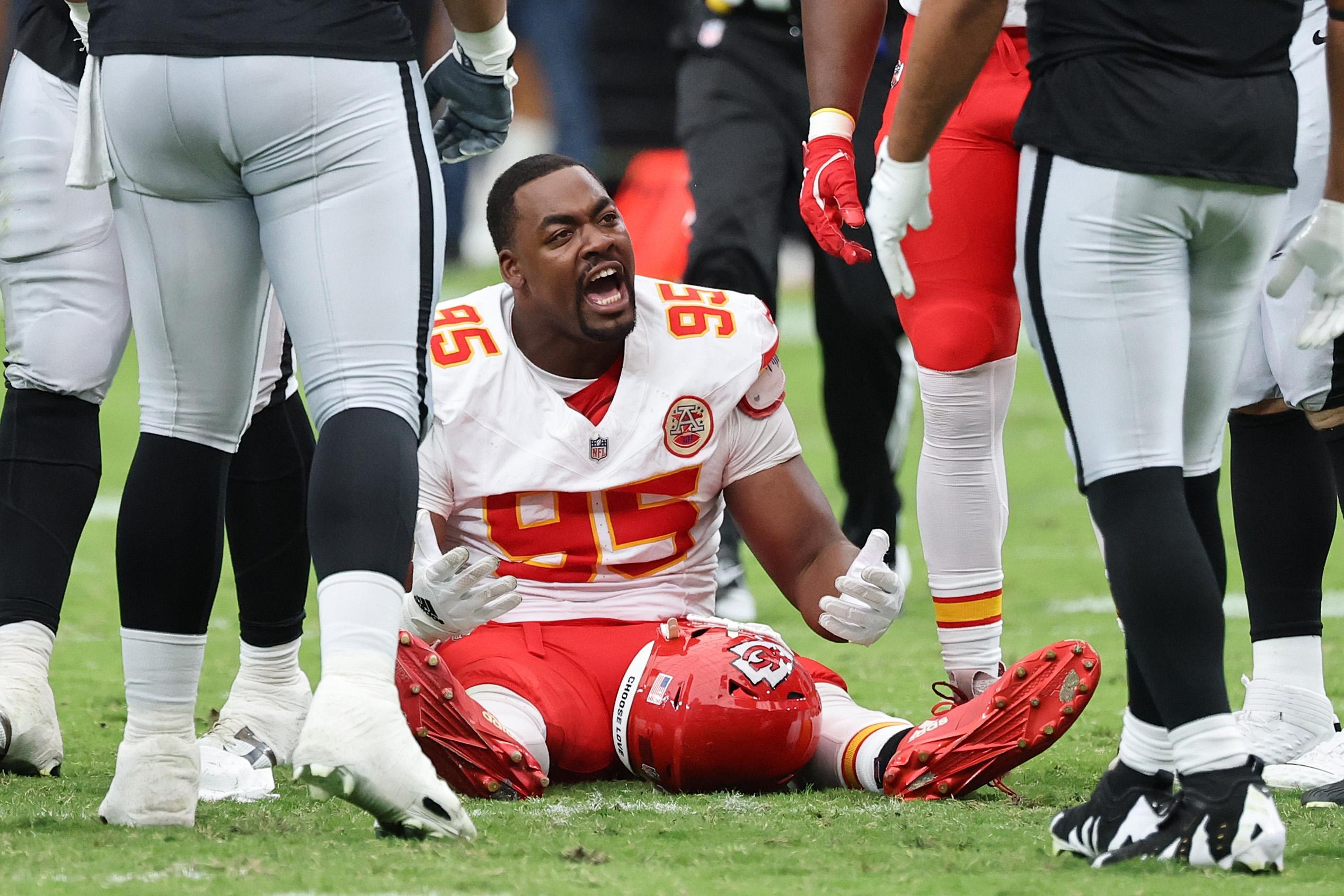 Chris Jones sentado no gramado com o uniforme dos Chiefs.