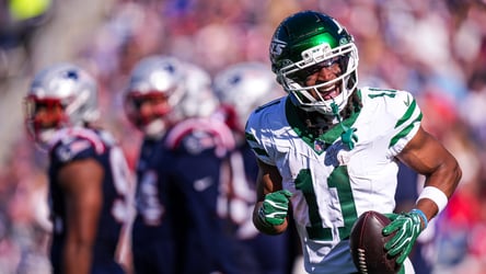 Recebedor dos Jets avança com a bola diante dos Patriots.