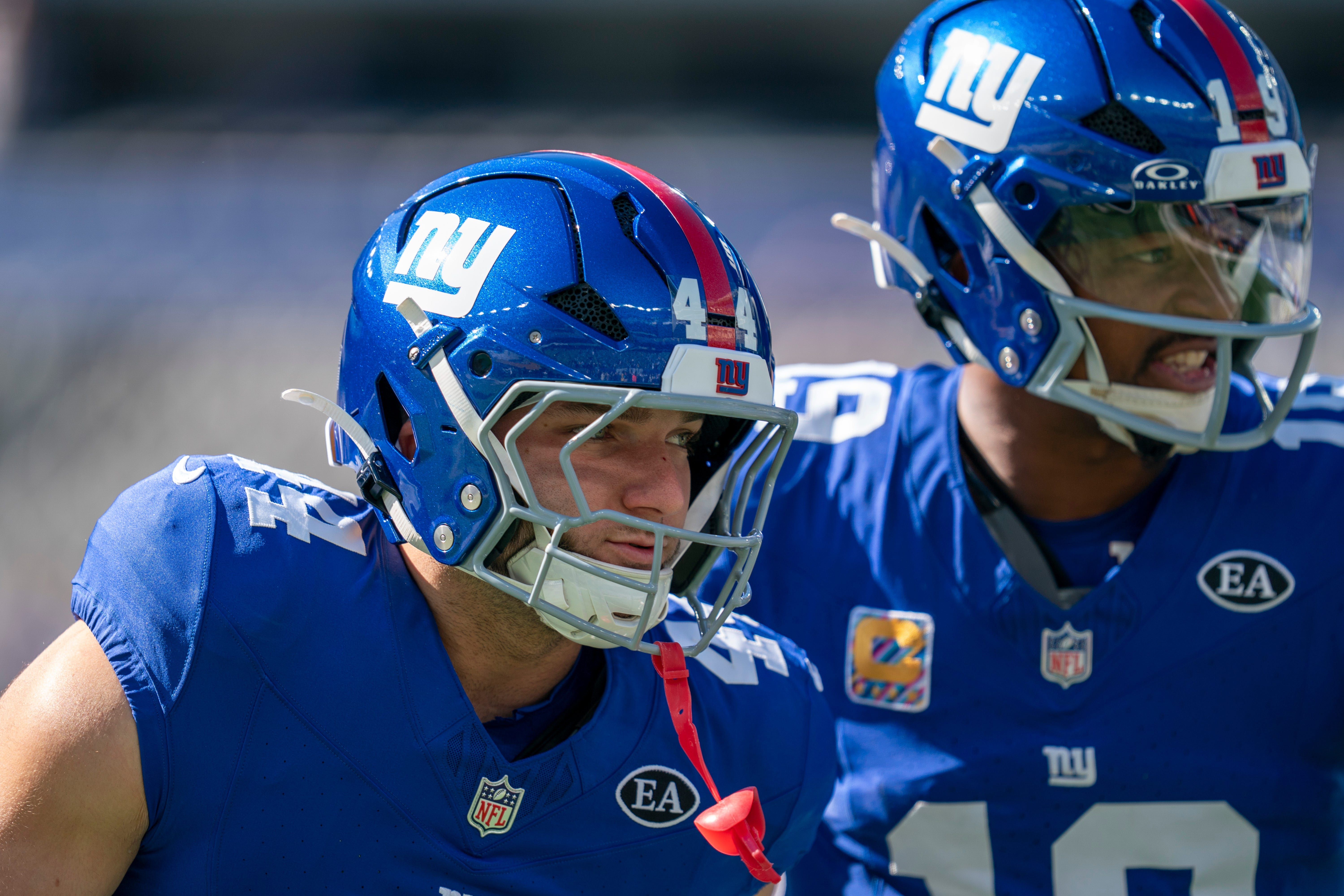 Cam Skattebo ao lado de um companheiro dos Giants.