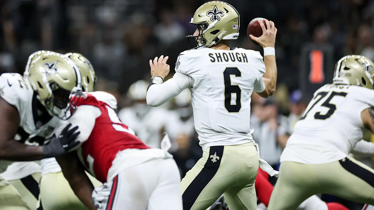 Quarterback prepara um passe sob pressão da defesa.