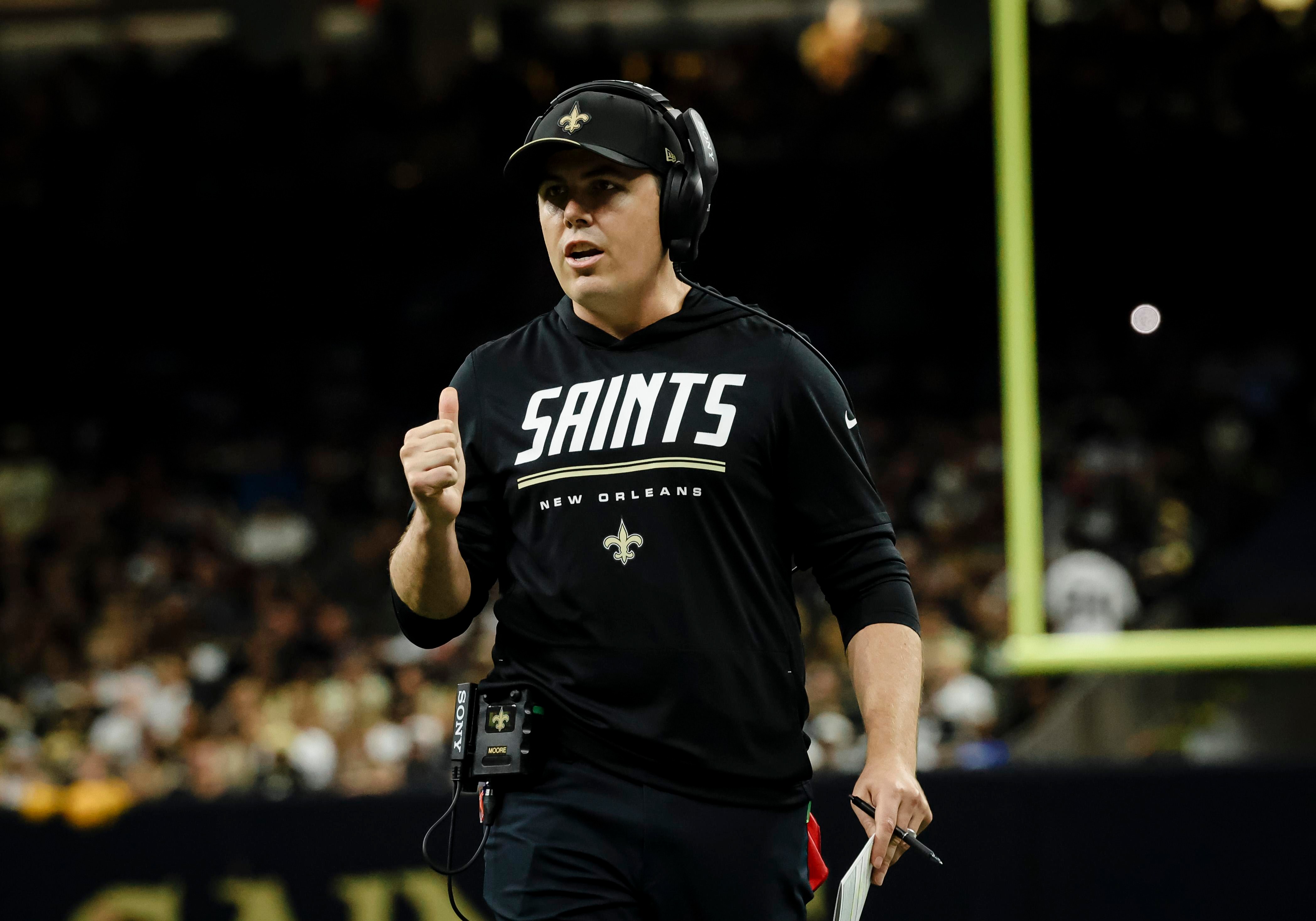 Kellen Moore acompanha uma partida dos Saints na lateral do campo.