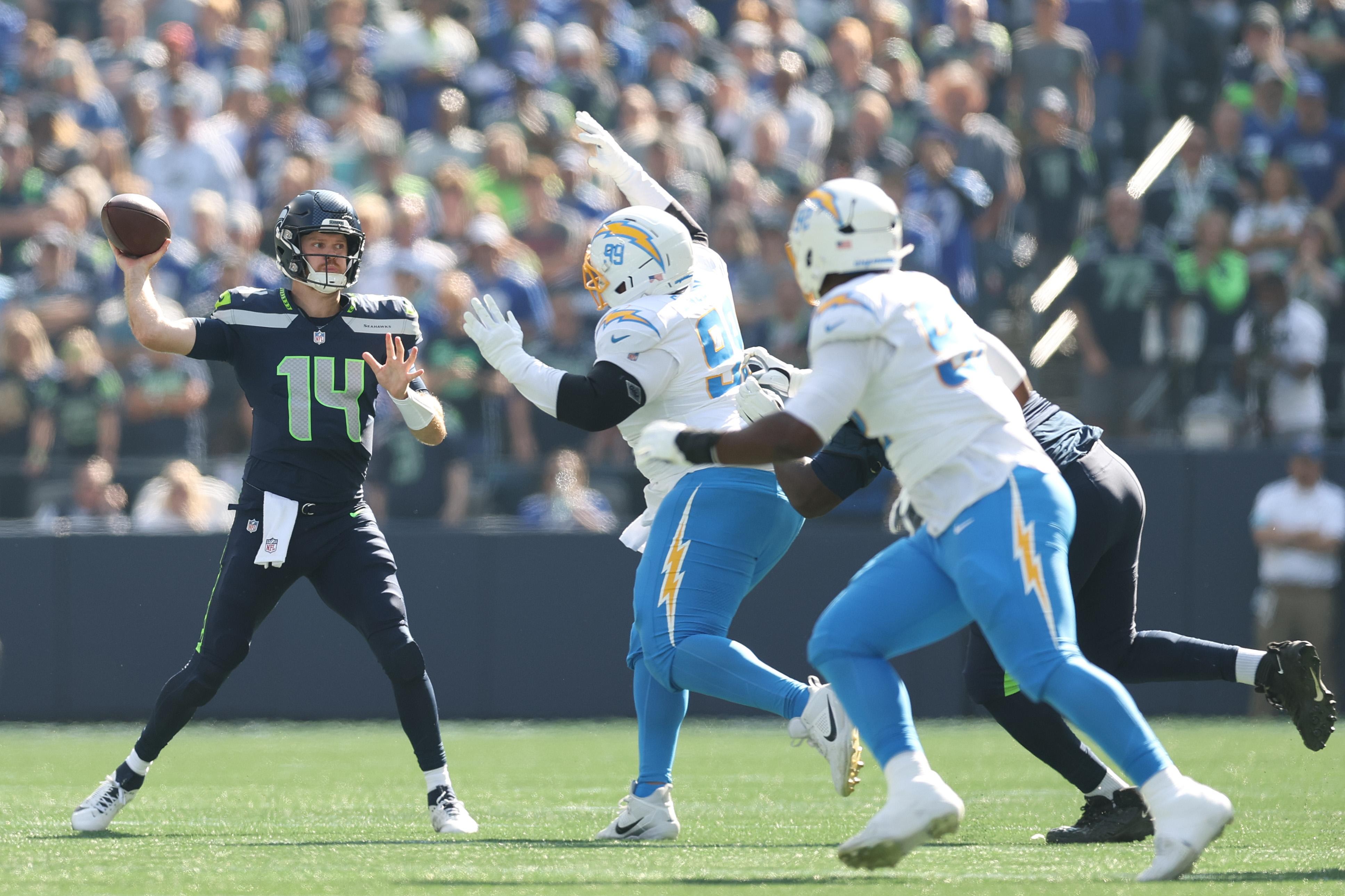 Sam Darnold lança pelos Seahawks diante da pressão dos Chargers.