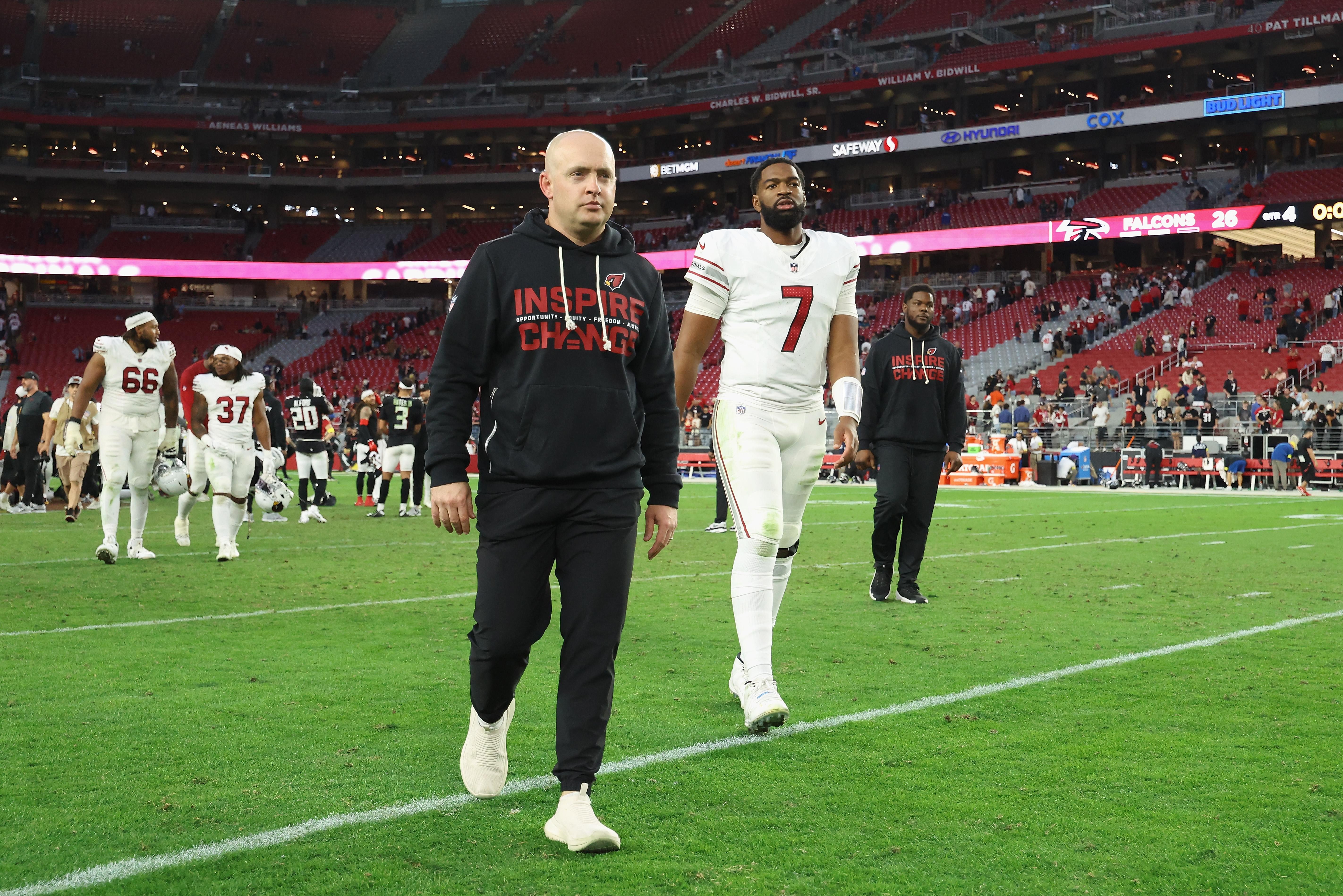 Drew Petzing e Jacoby Brissett deixam o campo após a derrota dos Cardinals para os Falcons em Glendale, em 21 de dezembro de 2025.