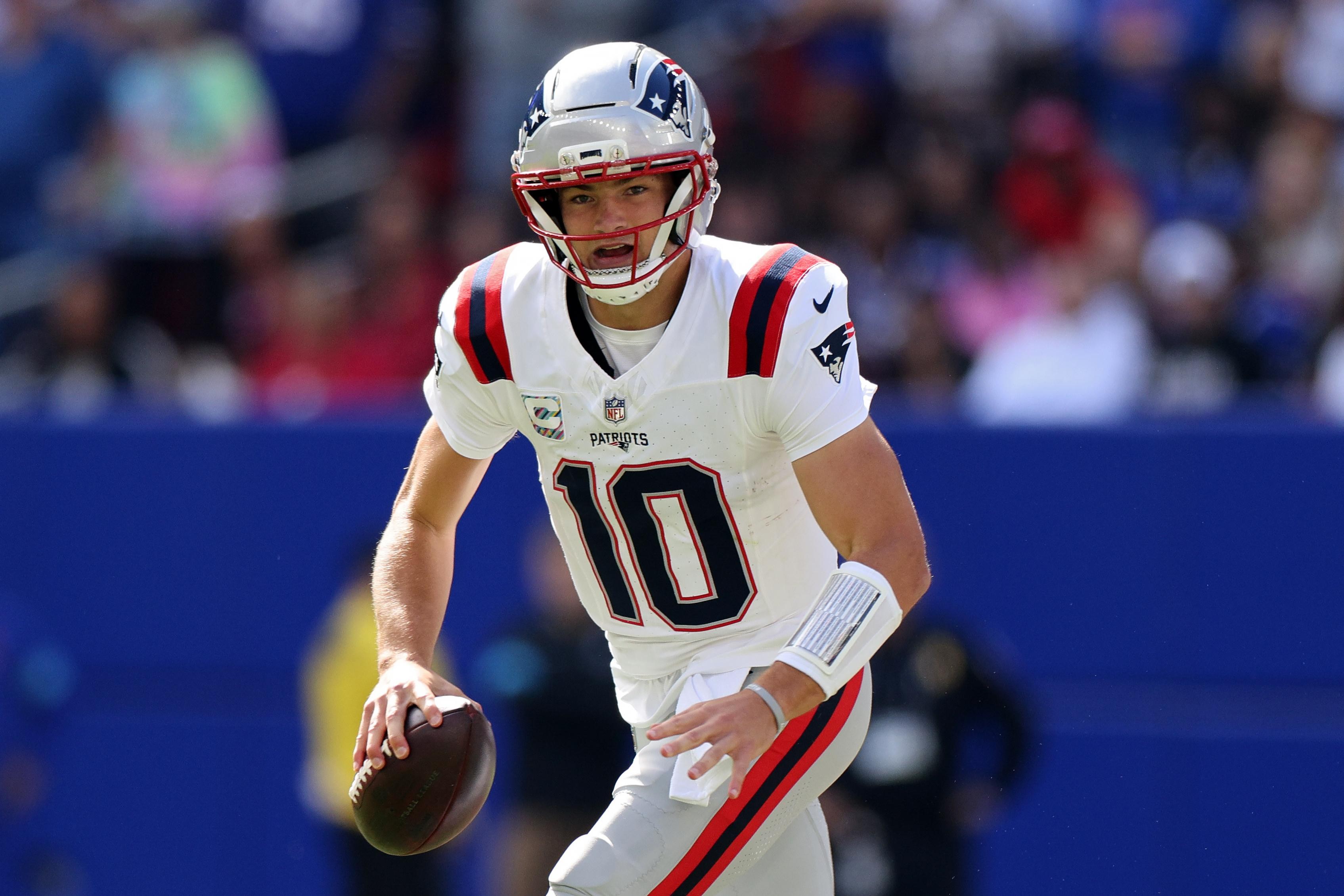 Drake Maye procura espaço para lançar pelos Patriots.
