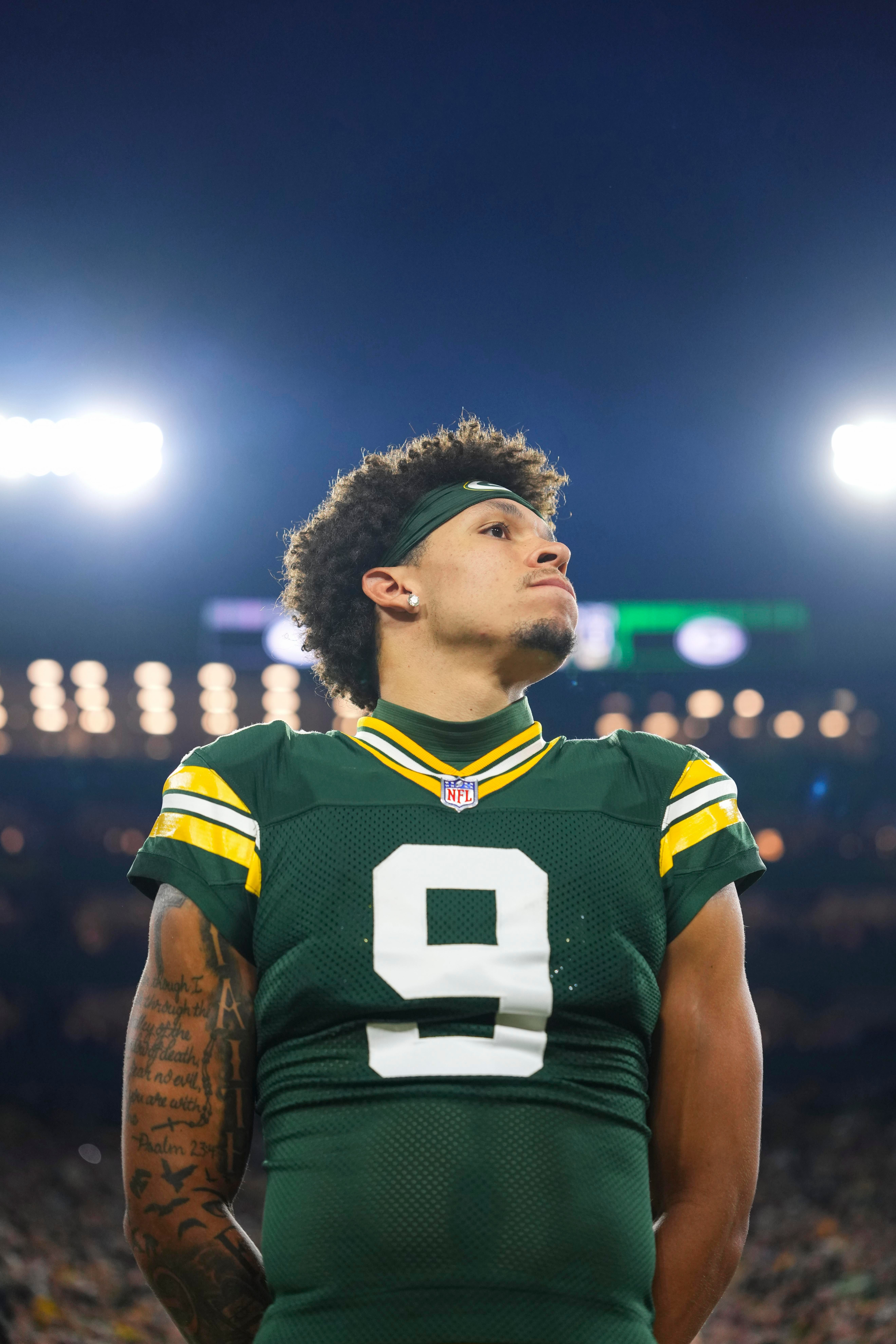 Christian Watson acompanha o hino antes do jogo dos Packers contra os Falcons, no Lambeau Field, em 24 de setembro de 2026.