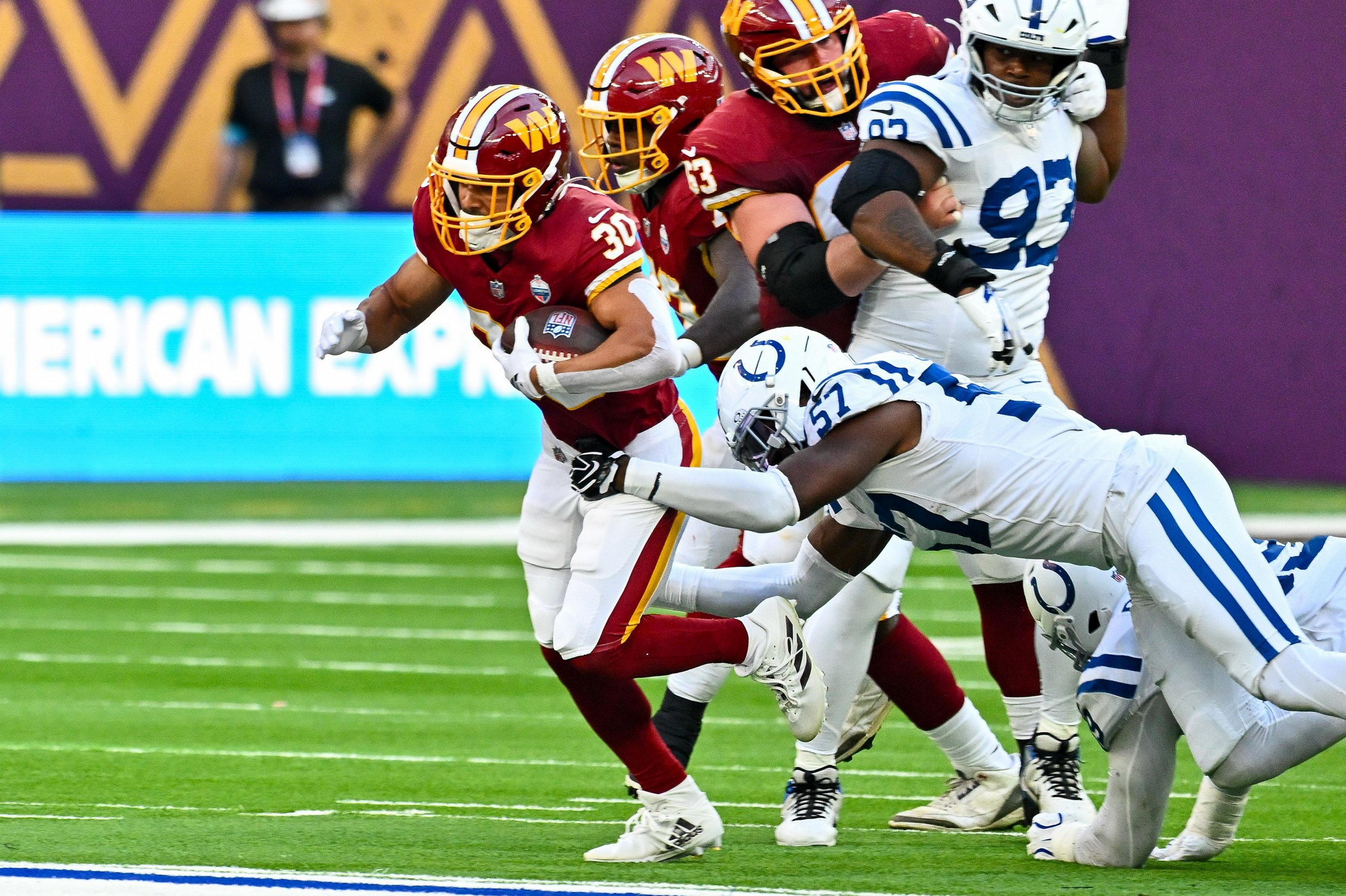 Robert Henry Jr., dos Commanders, é parado por Jaylon Carlies, dos Colts, em Londres, em 4 de outubro de 2026.