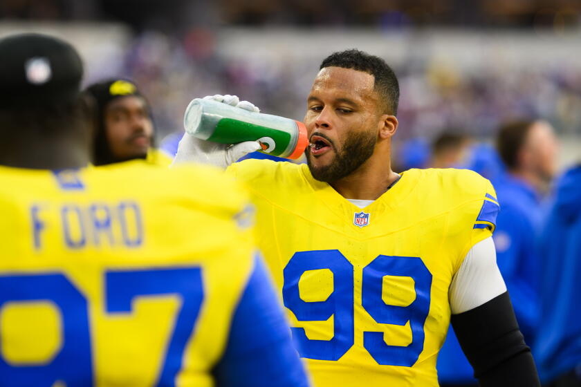 Aaron Donald, defensor dos Rams, junto aos companheiros na lateral do campo.