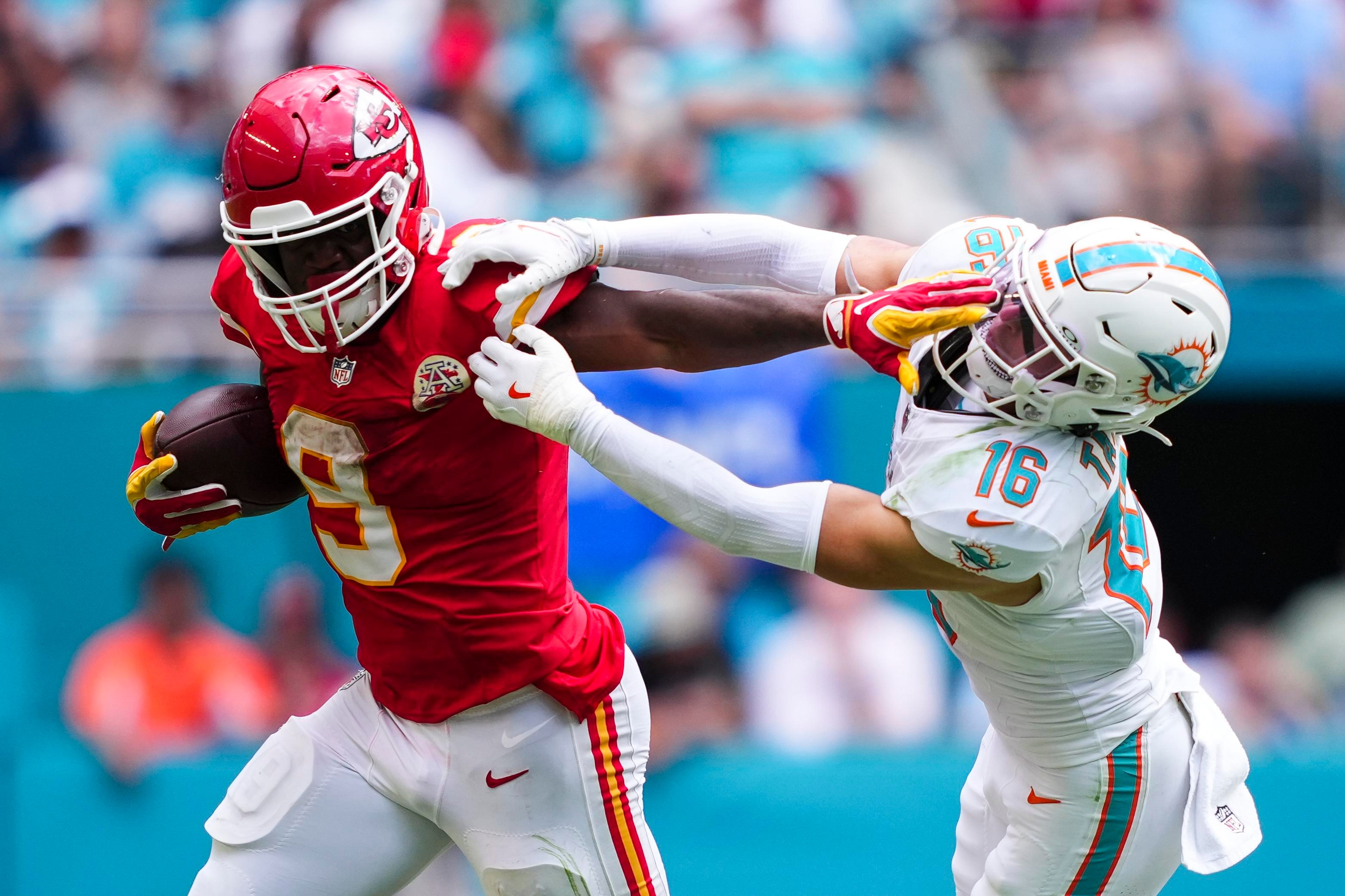 Jogador dos Chiefs avança com a bola contra os Dolphins.
