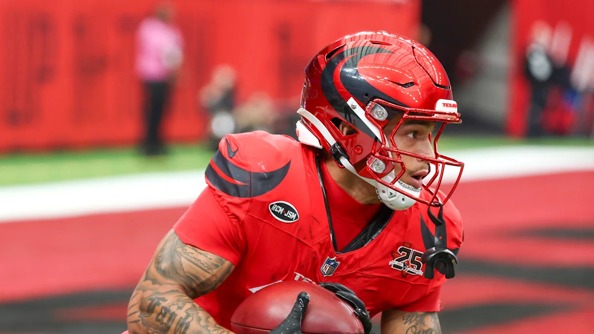 Jogador dos Texans carrega a bola durante atividade em campo.