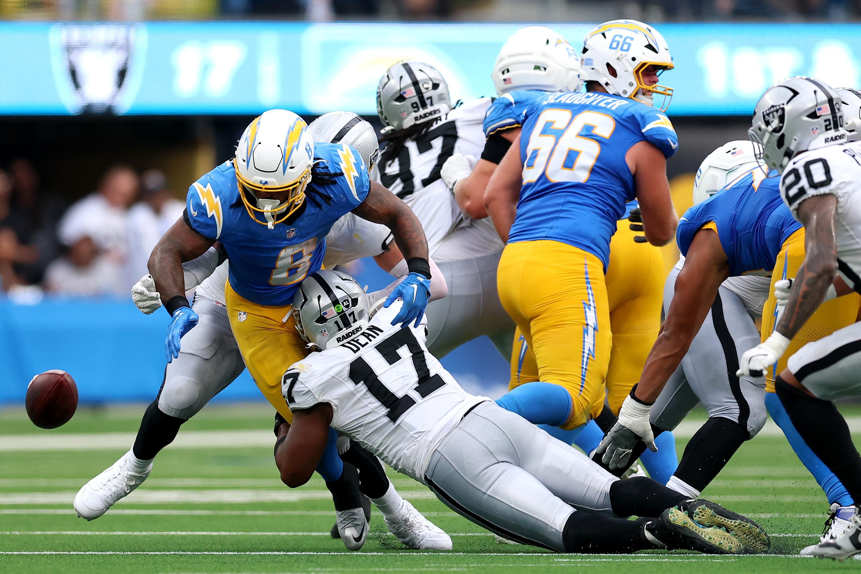Jogadores de Raiders e Chargers disputam uma jogada.