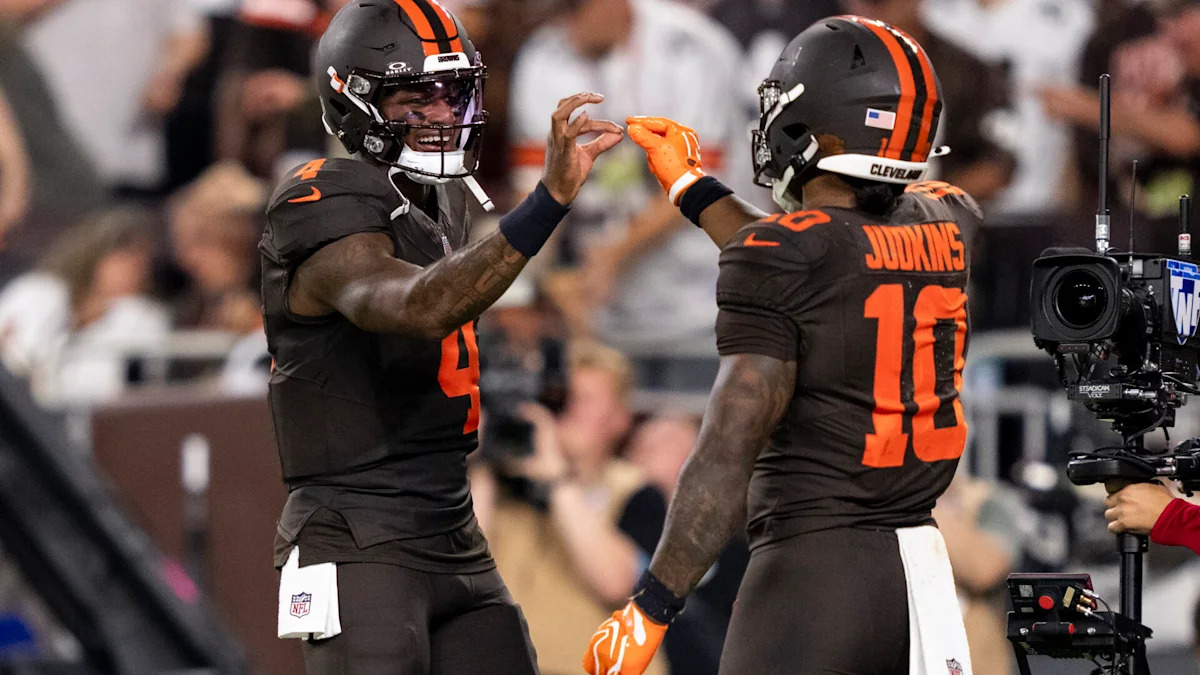 Jogadores dos Browns fazem gesto de comemoração em campo.