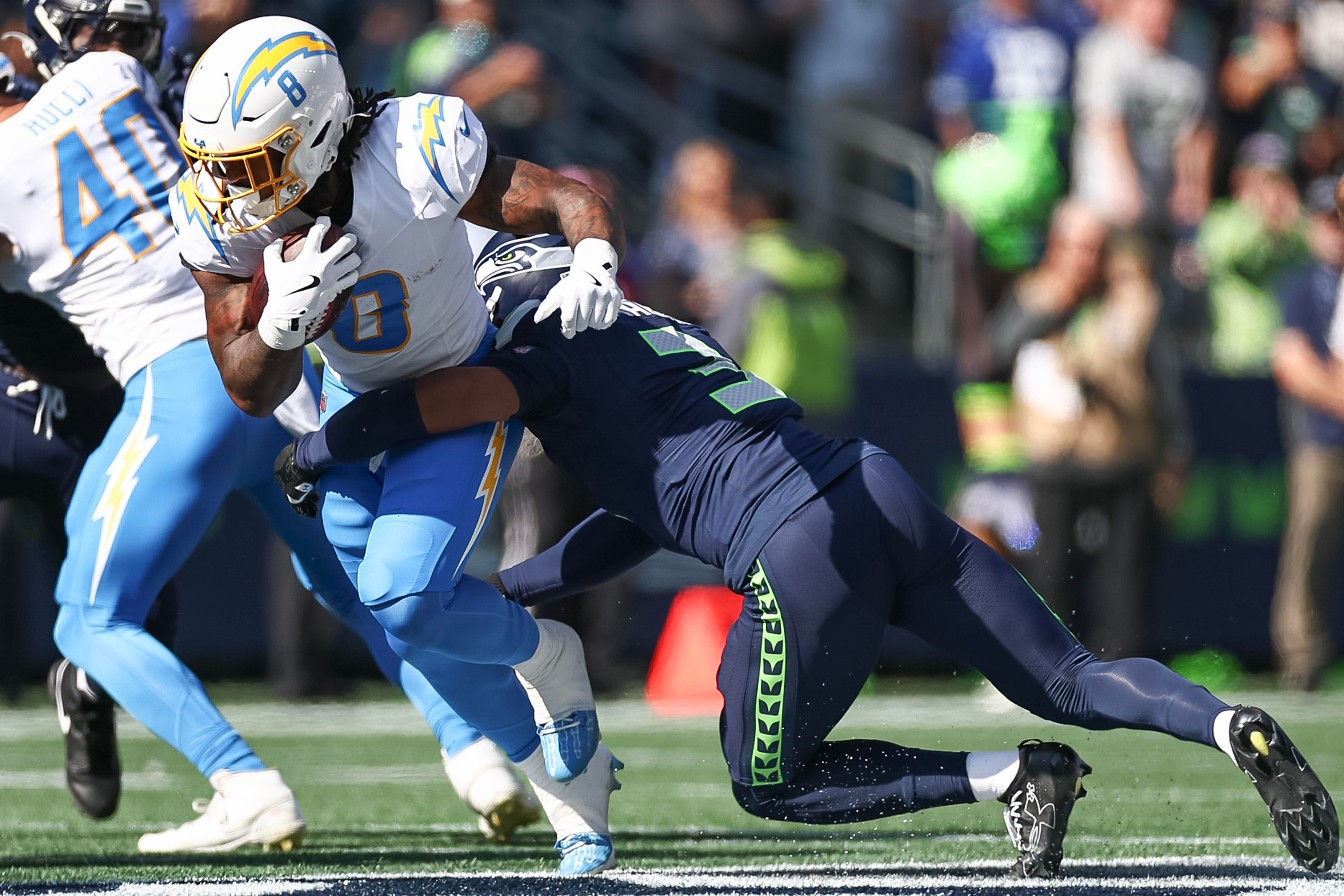 Josh Jobe, dos Seahawks, disputa uma jogada com Tre Harris, dos Chargers.