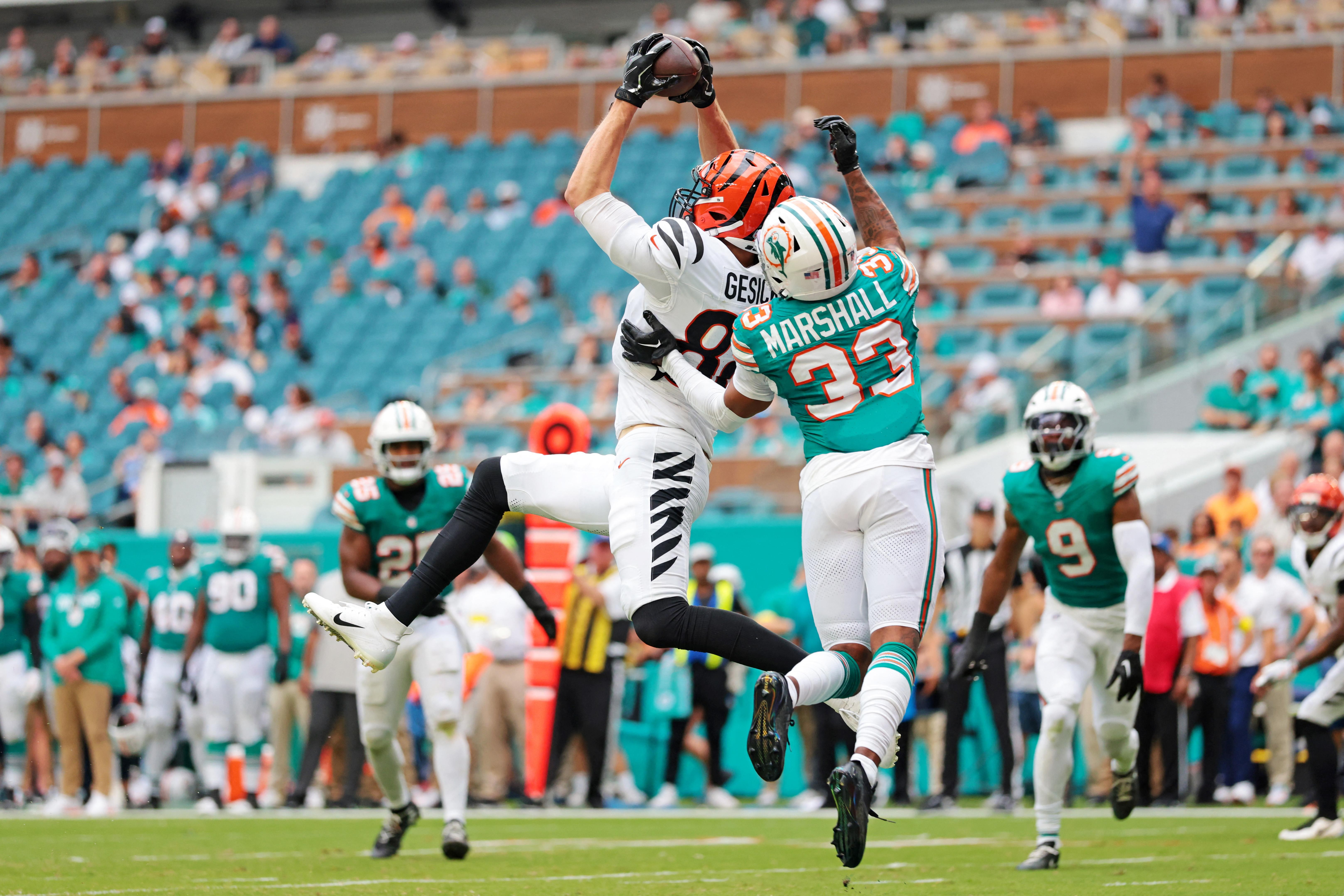 Joe Burrow lança a bola sob pressão da defesa dos Dolphins.