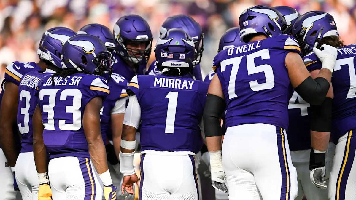 Jogadores do Minnesota Vikings reunidos em campo.