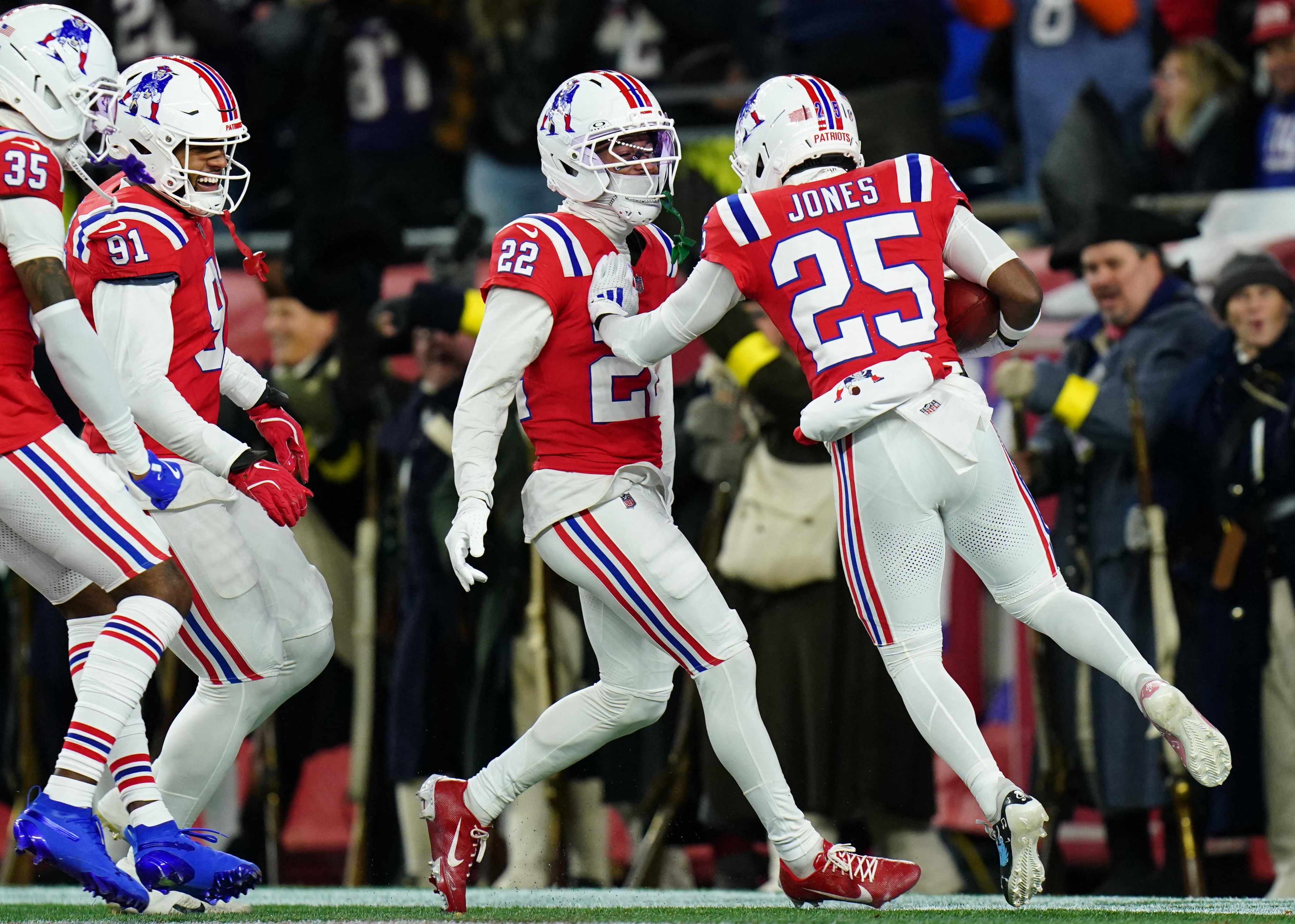 Jogadores da secundária dos Patriots reunidos em campo.