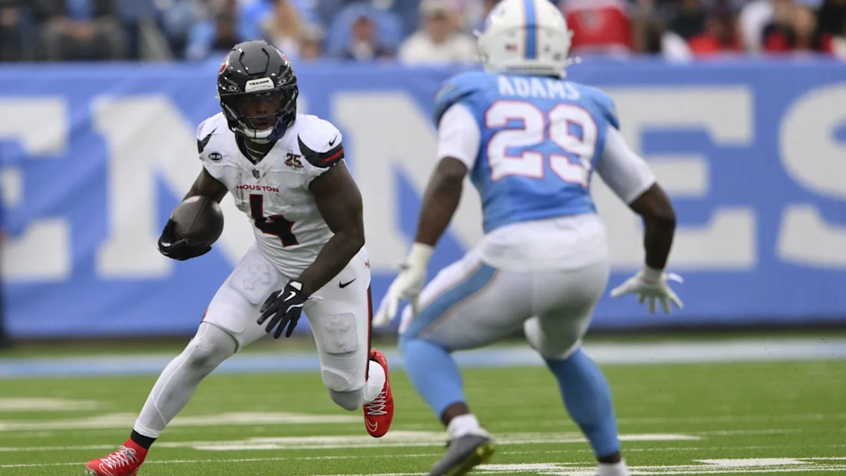 Woody Marks corre com a bola pelos Texans contra os Titans.